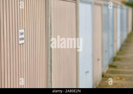 Rangée de portes de garage avec un signe sur la première porte qui dit ' Einfahrt freihalten ' (en anglais : Tenir à l'entrée Effacer ). Vu en Allemagne en novembre. Banque D'Images