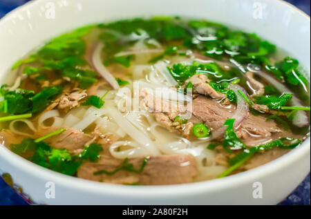 Soupe de boeuf Soupe pho bo, la cuisine vietnamienne, premier cours avec les nouilles et les légumes soupe dans un bol blanc, gros plan. L'alimentation de rue Banque D'Images