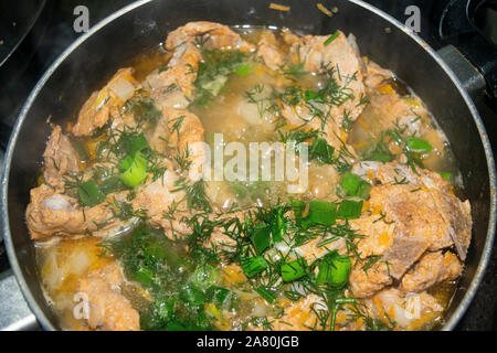 La viande avec les oignons, carottes, aneth et le laurier est mijotée dans une casserole. La cuisine maison Banque D'Images
