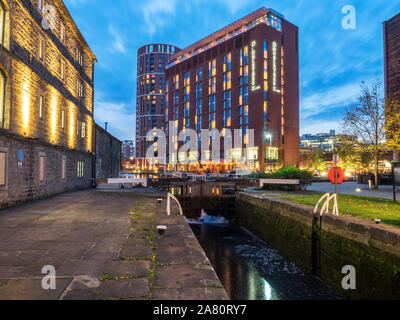 Vieux canal entrepôt par la rivière de blocage et d'hôtel moderne à quai Grenier au crépuscule Leeds West Yorkshire Angleterre Banque D'Images