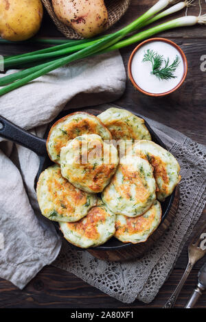 Des galettes de pommes de terre poêlées latkes dans iron skillet sur fond de bois rustique. La nourriture traditionnelle juive pour Hannukah célébration. Haut de la vie Banque D'Images