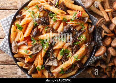 Servant des pâtes penne avec du miel et des champignons grillés sauce tomate close-up dans une assiette sur la table. Haut horizontale Vue de dessus Banque D'Images