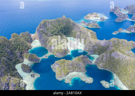 Îles de calcaire érodé fortement augmenter à partir de la magnifique paysage marin tropical, dans la région de Raja Ampat, en Indonésie. Cette région est connue pour sa biodiversité. Banque D'Images