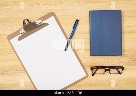 Mise à plat, vue du dessus table office 24. Espace de travail avec clip vierge, stylo, lunettes et sur table en bois. Des maquettes, copiez l'espace. Concept de travail Banque D'Images