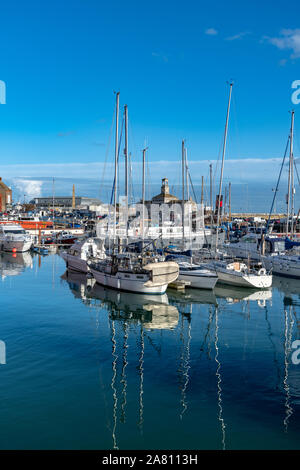 La fin de l'après-midi au port de Ramsgate. Avec des bateaux de pêche, des yachts, des petits bateaux et des bateaux de vitesse. Ciel bleu profond et réflexions sur la mer. Banque D'Images