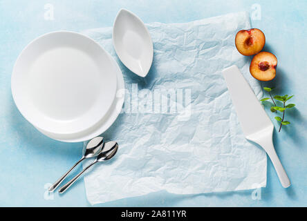 Assiettes et couverts vides comme un arrière-plan alimentaire sur bleu Banque D'Images