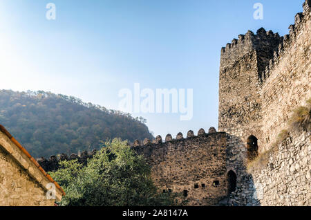 Tour et remparts de l'ancienne forteresse Ananuri sur l'arrière-plan de montagnes avec des forêts en Géorgie à l'automne Banque D'Images