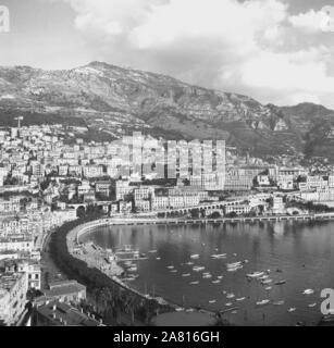 Années 1950, historique, une vue sur Port Hercule, le port en eau profonde de Monaco et le paysage environnant, montrant les buidlings du célèbre quartier de Monte Carlo au pied de la colline rocheuse sur la rivière française. Banque D'Images