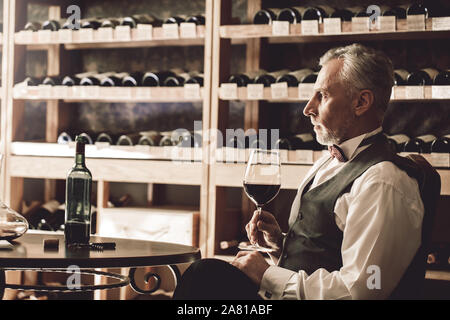 Sommelier Concept. Senior avec verre de vin à côté pensive Banque D'Images
