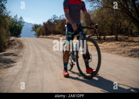 Cycliste homme debout sur un chemin de terre avec son vélo. Banque D'Images