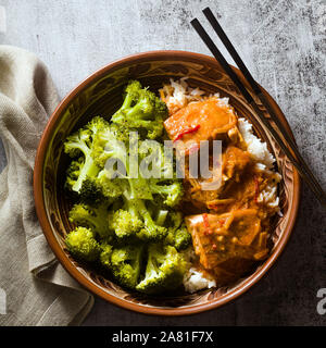 Dans un plat de saumon thaï sauce coco avec des brocolis et du riz dans un bol d'argile avec des baguettes . Alimentation saine de vitamine B5... Banque D'Images