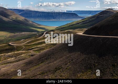 Route de gravier serpente à travers un paysage volcanique, près de Hrafnseyri, Westfjords, Islande Banque D'Images