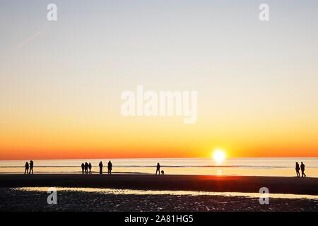 Les gens sur la plage au coucher du soleil sur la mer du Nord, mer du Nord, Schleswig-Holstein mer des Wadden Parc National, Schleswig-Holstein Banque D'Images