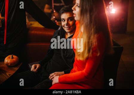 Jeune homme dans un costume de zombie Halloween regarde une belle fille Banque D'Images