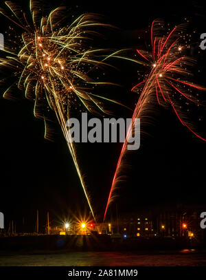 North Berwick, East Lothian, Écosse, Royaume-Uni, 5 novembre 2019. Guy Fawkes feu d'artifice de nuit illuminez le ciel sombre froid lors d'une soirée venteuse sur la côte du Firth of Forth Banque D'Images