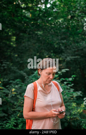 Female hiker using smartphone en forêt, selective focus Banque D'Images