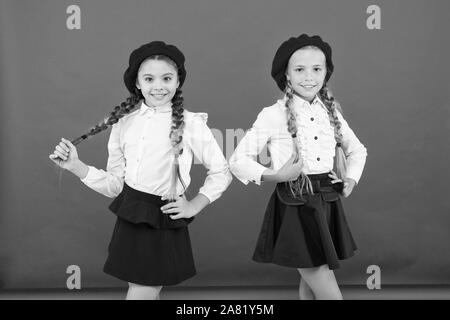 Les enfants belles filles de long cheveux tressés. Style de fantaisie. Peu de filles avec des tresses, des prêts pour l'école. Concept de la mode de l'école. L'École de l'amitié. Sur la même vague. Usure uniforme de l'école formelle écolières. Banque D'Images