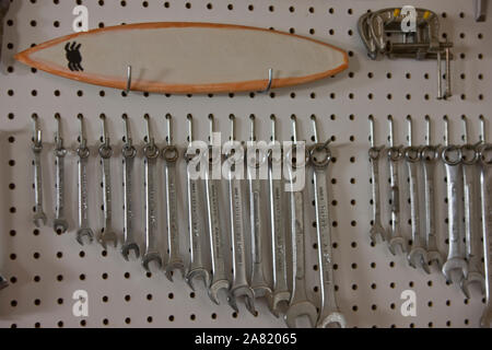 Différentes tailles de clés d'argent suspendu dans une ligne sur une carte perforée. Banque D'Images