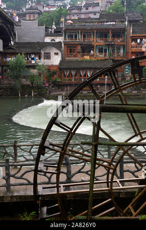 Une roue de l'eau alimenté par le Tuo Jiang River célèbre le charme du vieux monde à Fenghuang ville ancienne dans la région autonome du Tibet, la Chine. Banque D'Images