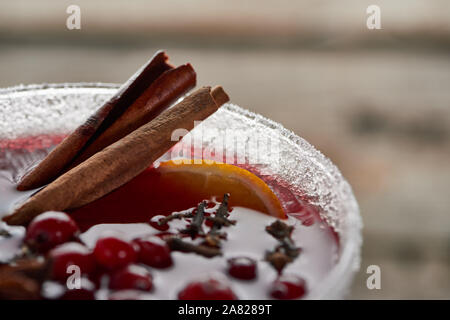 Vue rapprochée de rouge vin chaud épicé avec des baies, d'anis, les tranches d'orange et la cannelle dans le verre décoré avec du sucre Banque D'Images