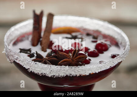 Vue rapprochée de rouge vin chaud épicé avec des baies, d'anis, tranche d'orange et la cannelle dans le verre avec du sucre Banque D'Images