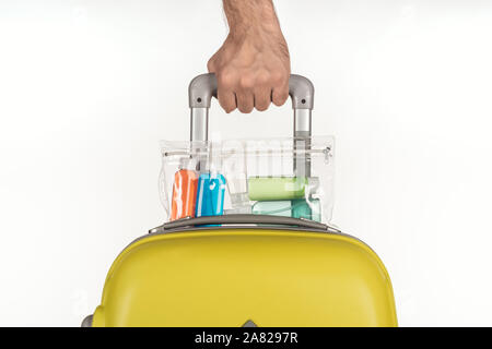 Portrait d'homme tenant un sac de voyage avec sac cosmétique avec des bouteilles avec des liquides colorés sur fond blanc Banque D'Images