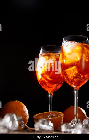 Aperol Spritz, dans les verres, des oranges et des cubes de glace sur fond noir Banque D'Images