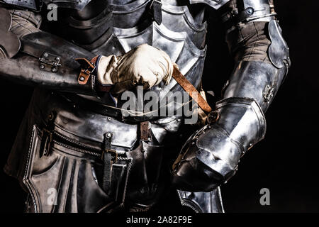 Portrait de chevalier en armure tenant un sabre isolated on black Banque D'Images