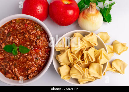 Tortellini Bolognaise avec pâtes Fagottini (savez également comme Bolognesa ou Bolonhesa) de sauce dans un bol blanc isolé en fond blanc, lumière douce, studio Banque D'Images