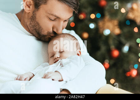 Happy father holding et d'embrasser l'enfant endormi Banque D'Images