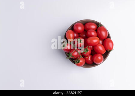 Tomate cerise raisin ou de branche. Tas de tomates raisin rouge brun dans un bol, isolé sur fond blanc Banque D'Images