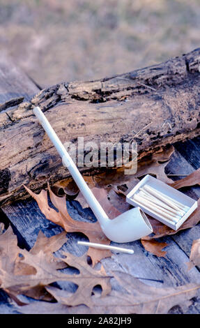 Pipe en argile avec des allumettes sur un fond rustique Banque D'Images