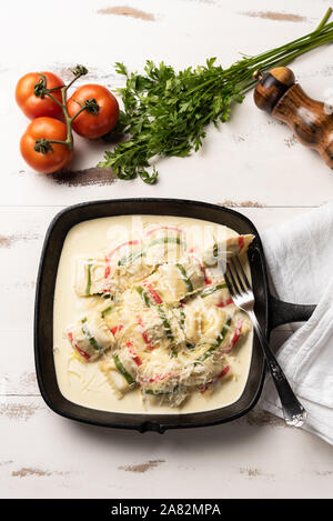 La couleur fait main ; pâtes Ravioli Ravioli pâtes multicolores dans une poêle de fer, noir sur blanc en bois fond de table. Banque D'Images