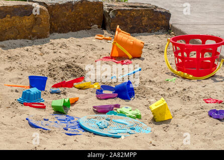 Les jouets de sable coloré jeter abandonné dans le sable, prêt pour les enfants temps de jeu créatif Banque D'Images