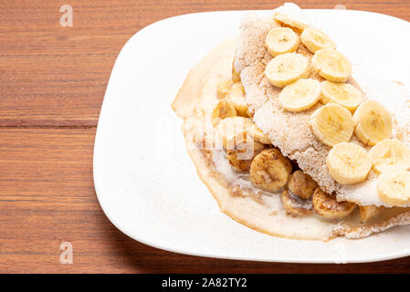 Rempli de tapioca banane, la cannelle et le lait condensé, sur fond de bois. Un pain plat à base de manioc (également connu sous le nom de bammy, casabe, beiju, bob, b Banque D'Images