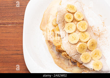 Rempli de tapioca banane, la cannelle et le lait condensé, sur fond de bois. Un pain plat à base de manioc (également connu sous le nom de bammy, casabe, beiju, bob, b Banque D'Images