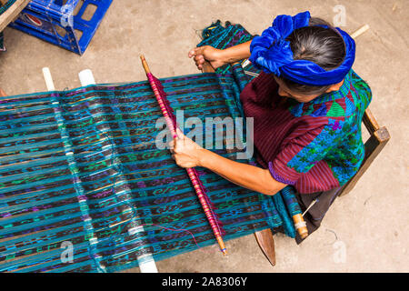 Une femme en costume traditionnel Maya tisse le tissu sur un métier à tisser dans Santa Cruz la Laguna, Guatemala. Vue de dessus. Banque D'Images