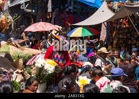 Des foules de gens viennent de villes environnantes pour assister le marché du dimanche à Chichicastenango, Guatemala. Une quiche les femmes mayas vend des fleurs. Banque D'Images