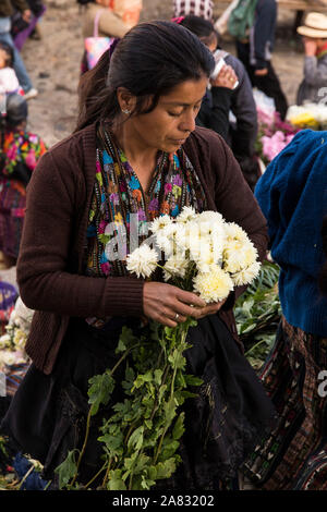 Femme Maya quiche en costume traditionnel vente de fleurs sur les marches de l'église de Santo Tomas à Chichicastenango, Guatemala le jour du marché. Banque D'Images