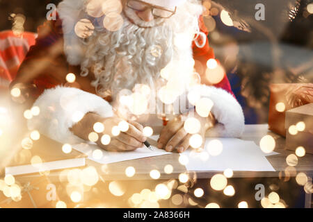 Père Noël faisant liste des dons à l'accueil Banque D'Images