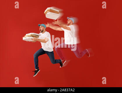 Hommes saut courier avec boîtes à pizza sur un fond de couleur Banque D'Images