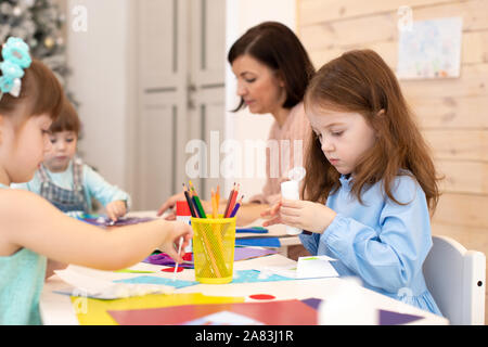 Groupe d'enfants sur la leçon en maternelle. Les enfants avec l'enseignant l'étude artworking. Activités en classe d'âge préscolaire Banque D'Images