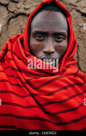 JUN 24, 2011 Serengeti, Tanzanie - Portrait de l'homme de la tribu Masai Masai ou en drap rouge Yeux regardant la caméra. Ride et de détail visage clairement Banque D'Images