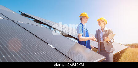 Travailleur de la construction et de l'investisseur en installation solaire shaking hands Banque D'Images