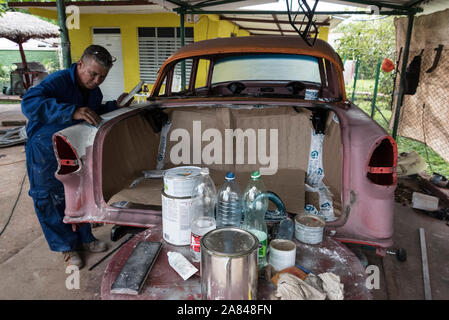 Une voiture cubaine carrossier, travaillant sur une voiture classique dans un petit village dans le garage Valle de Viñales, Pinar del R'o Province, à l'ouest de Cuba, Cuba Banque D'Images