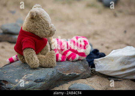 Deux nounours assis sur un rocher sur la plage. Banque D'Images