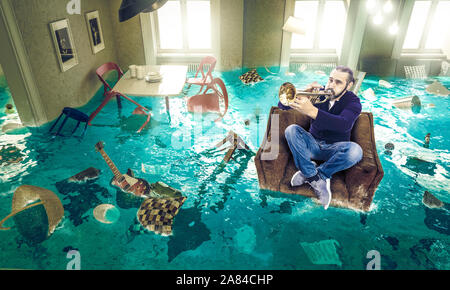 L'homme joue de la trompette dans une chaise flottante dans un complètement inondé la salle de séjour. Quelle que soit la situation, il pense seulement de la musique. Banque D'Images