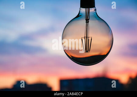 Coucher de soleil dans une ampoule.Concept d'électricité.Heure de la terre.Consommation d'énergie et conservation de l'environnement, économie d'énergie.Gaz et énergie Banque D'Images