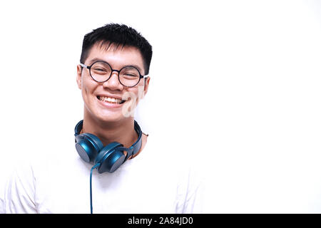 Beaux jeunes hommes beau sourire et l'écoute de la musique avec le smartphone et casque Banque D'Images