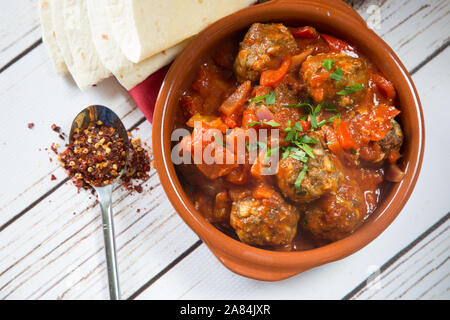 Un plat turc traditionnel composé de boulettes de viande cuites dans une sauce tomate et poivron rouge servi avec du riz Orzo. Mini Sebzeli Kofte. Banque D'Images